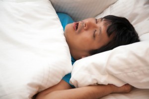 Asian man is snoring in bed and his have sleep apnea, Health care concept.