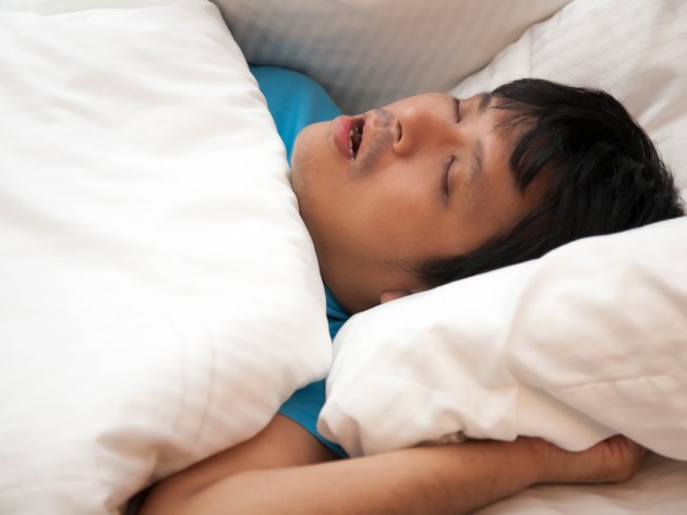 Asian man is snoring in bed and his have sleep apnea, Health care concept.